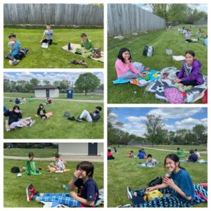 Students eating picnic lunches outside