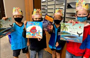 Students holding up books for their birthdays