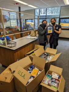 2 6th grade girls in front of donations for Ukraine